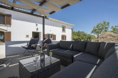 a patio with a couch and chairs and a table at Villa Angel in Loulé