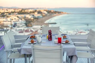 a table with plates of food and a view of the beach at Infinito penthouse Luxury Best terrace Albufeira in Albufeira