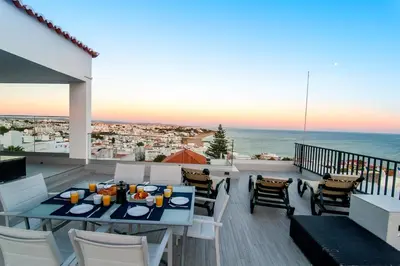 a table and chairs on a balcony with a view of the ocean at Infinito penthouse Luxury Best terrace Albufeira in Albufeira