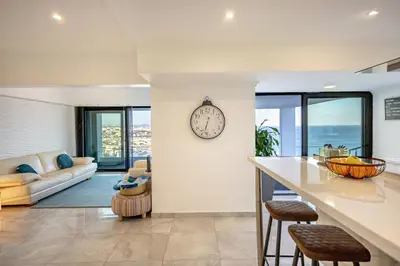 a kitchen and living room with a clock on the wall at Infinito penthouse Luxury Best terrace Albufeira in Albufeira