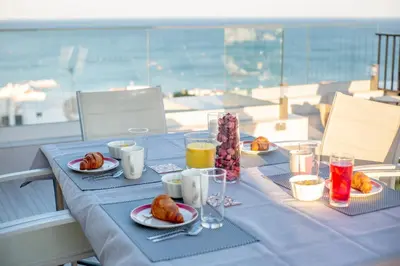 a table with a blue table cloth with breakfast food on it at Infinito penthouse Luxury Best terrace Albufeira in Albufeira