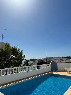 a kitchen with wooden cabinets and a microwave at Vila Mar Central in Albufeira