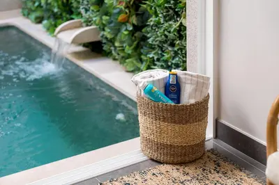 a basket of toothbrushes sitting next to a swimming pool at Downtown Pool House in Faro
