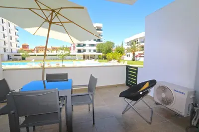 a patio with a table and chairs and an umbrella at Neptuno 97 - Clever Details in Vilamoura