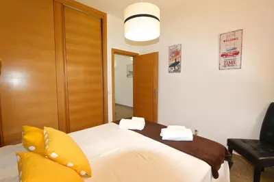 a bedroom with a large white bed with yellow pillows at Neptuno 97 - Clever Details in Vilamoura