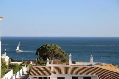 a sailboat in the ocean with a house and a tree at Dreamly Sea in Albufeira