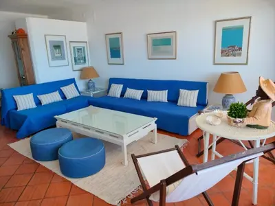 a living room with a blue couch and a table at Dreamly Sea in Albufeira