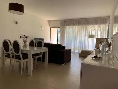 a kitchen and living room with a table and chairs at Cavalo Preto Luxury Beach Resort in Quarteira