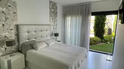 a white bedroom with a bed and a window at Cavalo Preto Luxury Beach Resort in Quarteira