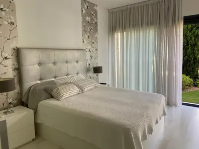 a white bedroom with a large bed and a window at Cavalo Preto Luxury Beach Resort in Quarteira