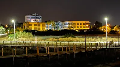 a city at night with buildings in the background at Cavalo Preto Luxury Beach Resort in Quarteira