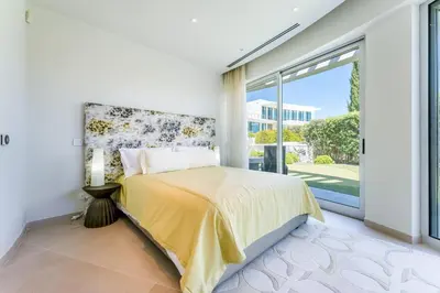 a bedroom with a bed and a large window at Villa Croesa - Vale de Lobo in Almancil