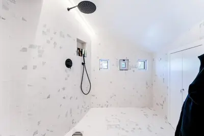 a bathroom with a shower with white tiles at Villa Croesa - Vale de Lobo in Almancil