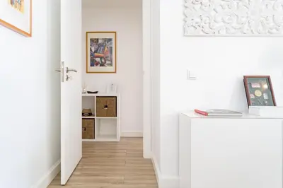 a hallway with white walls and a white door with a wooden floor at Vilamoura Marina Apartment with swimming pool in Vilamoura
