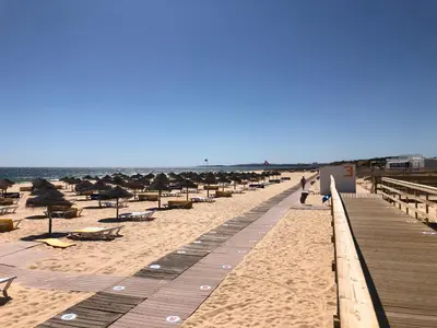 a beach with umbrellas and chairs and the ocean at Vilamoura Marina Apartment with swimming pool in Vilamoura