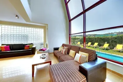 a living room with two couches and a large window at Vila Marina -BBQ, pool & garden- by Seareen in Albufeira
