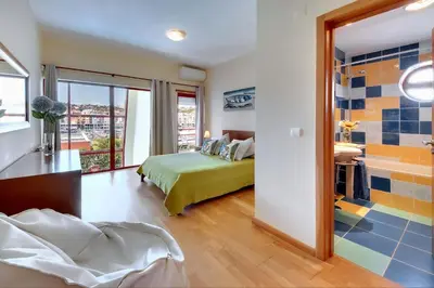 a bedroom with a bed and a bathroom at Vila Marina -BBQ, pool & garden- by Seareen in Albufeira