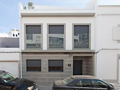 a black car parked in front of a white building at Faro Clara Suites in Faro