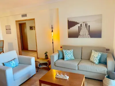 a living room with a couch and a table at Charming Apartment with Private Garden & Pool in Vilamoura