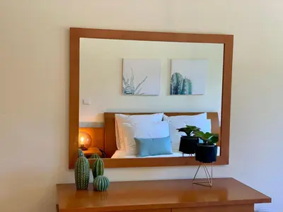 a mirror on a wall with a bed in a room at Charming Apartment with Private Garden & Pool in Vilamoura