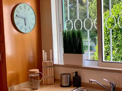 a clock on a wall next to a window at Charming Apartment with Private Garden & Pool in Vilamoura