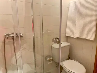 a bathroom with a toilet and a glass shower at Charming Apartment with Private Garden & Pool in Vilamoura