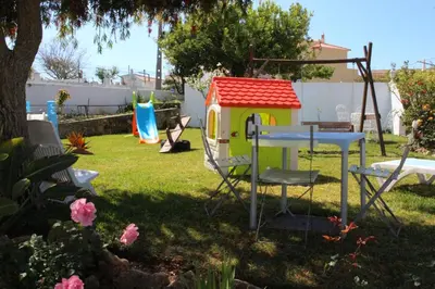 a backyard with a toy house and a table at Sunshine in Albufeira