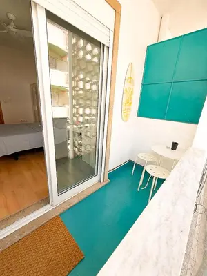 a room with a large window and a table with chairs at Surf Vibe Guest House in Faro