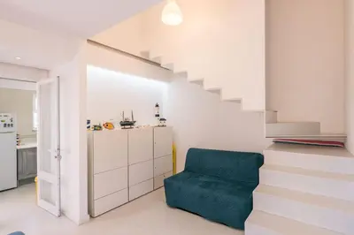 a stairway with a blue chair next to a staircase at LovelyStay - Two Bedroom Duplex at Vilamoura Marina in Vilamoura