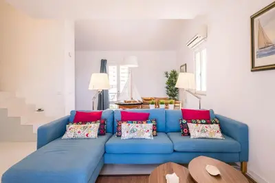a blue couch with pillows in a living room at LovelyStay - Two Bedroom Duplex at Vilamoura Marina in Vilamoura