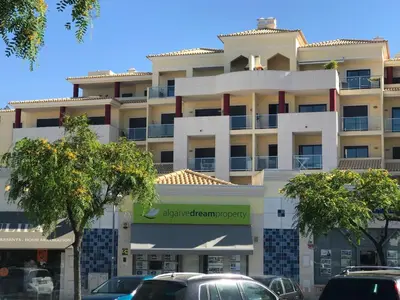 a large white building with cars parked in front of it at SOMAR Torre de Medronheira OLHOS DE AGUA ALBUFEIRA in Olhos de Água