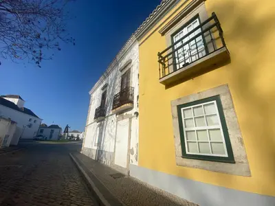 a yellow building with a window on a street at Casa Saudade luxury rooms in Faro