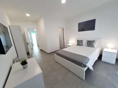 a bedroom with a bed and a tv in it at Lote 1 Aconchegante in Quarteira