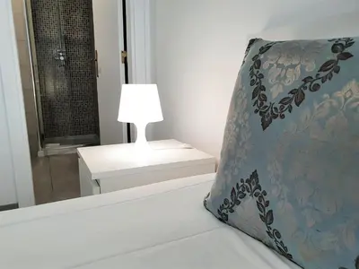 a bed with a pillow and a lamp in a room at Lote 1 Aconchegante in Quarteira