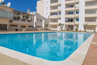 a swimming pool in front of a building at #005 Foxy B by Home Holidays in Albufeira