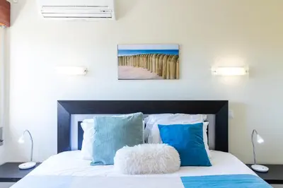 a bedroom with a bed with blue and white pillows at #005 Foxy B by Home Holidays in Albufeira