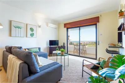 a living room with a couch and a balcony at #005 Foxy B by Home Holidays in Albufeira
