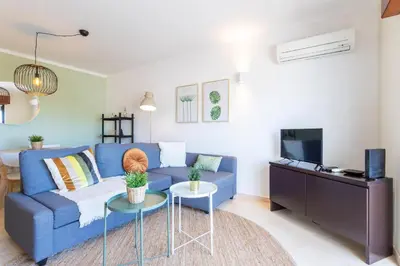 a living room with a blue couch and a tv at #005 Foxy B by Home Holidays in Albufeira