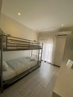 a bedroom with two bunk beds and a wooden floor at AL MMaria in Faro