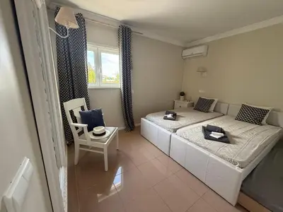 a small room with two beds and a chair at Dream House - Condominio com piscina aquecida e propriedade com 5 bicicletas incluindo 1 eletrica in Albufeira