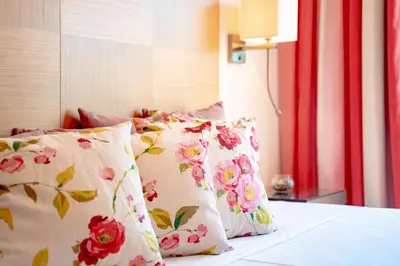 a bed with pink and white pillows on it at AL - Apartamento Vila Sol F5 AH in Quarteira