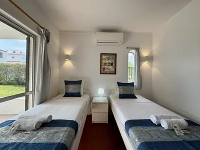a small room with two beds and a window at Vilamoura Ocean Villa with Pool by Homing in Vilamoura