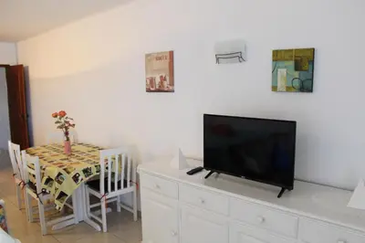 a living room with a table and a flat screen tv at Naturmar Praia in Albufeira