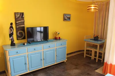 a blue dresser with a television on top of it at Naturmar Praia in Albufeira
