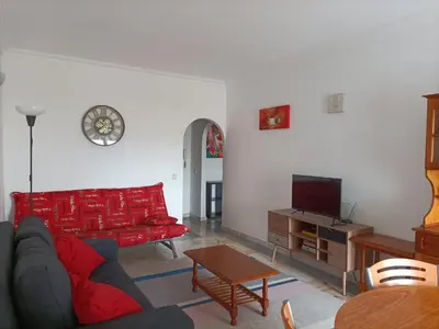 a living room with a red couch and a table at Oura Li in Albufeira