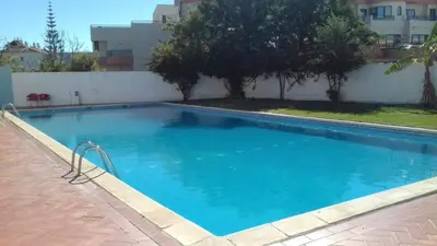 a large blue swimming pool next to a building at Oura Li in Albufeira