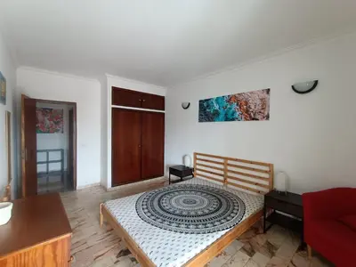 a bedroom with a bed and a red couch at Oura Li in Albufeira