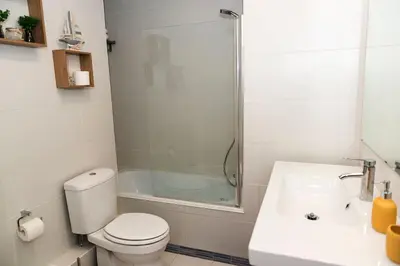 a bathroom with a toilet and a shower and a sink at Casa Olga Vieira in Albufeira