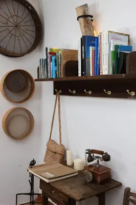 a wooden shelf with books on a wall with a desk at Monte das Cortelhas in Guia