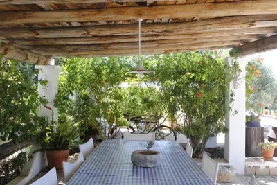 a table and chairs on a patio with trees at Monte das Cortelhas in Guia